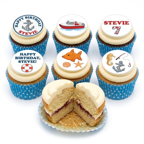 Six cupcakes with white icing and nautical-themed edible toppers including a fishing boat, anchor, fish, seahorse, and lifebuoy, in blue polka dot wrappers.
