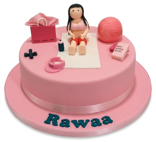 Pink round cake with female fitness figurine, gym ball, dumbbell, and personalised name.