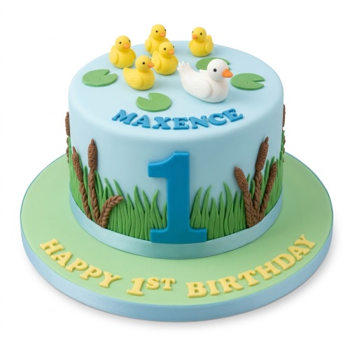 Light blue 1st birthday cake with white and yellow ducks, green lily pads, grass, and brown cattails.