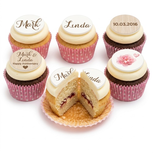 Assortment of cupcakes with white cream frosting, custom name and date toppers, and a pink rose decoration.