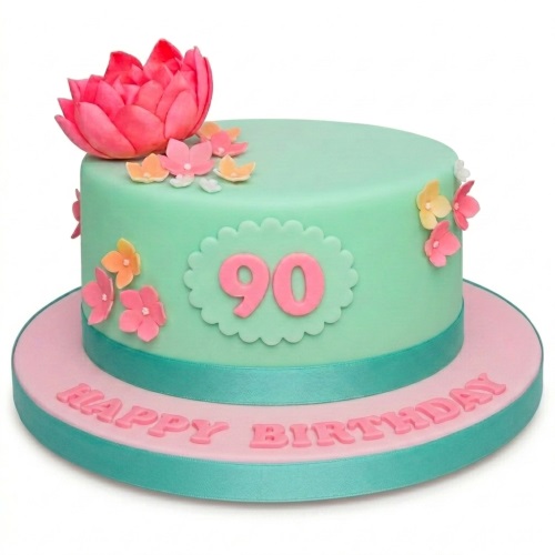 Round mint green birthday cake with pink lotus, small flowers, and custom age plaque.