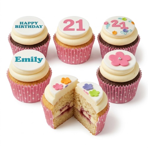 Assortment of floral birthday cupcakes with custom age and message toppers, pink polka dot wrappers.
