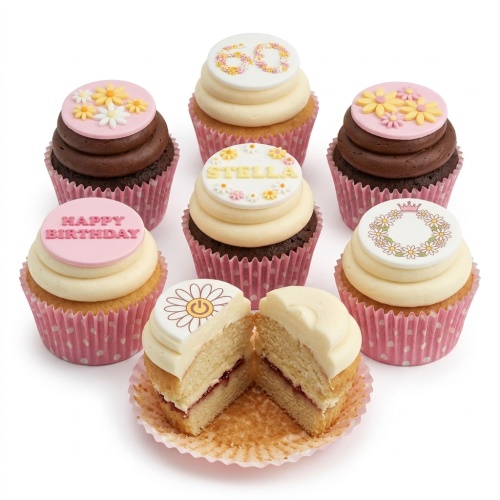 Assortment of daisy floral birthday cupcakes with pink and white polka dot wrappers, some with custom age and name toppers.