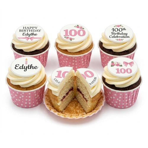 White and pink 100th birthday cupcakes with floral and bow toppers in polka dot cases.
