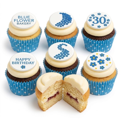 Vanilla and chocolate cupcakes with white icing, blue polka dot wrappers, and blue floral toppers.