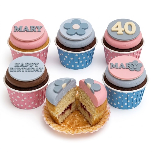 Pastel pink and blue cupcakes with floral and custom age/message toppers.