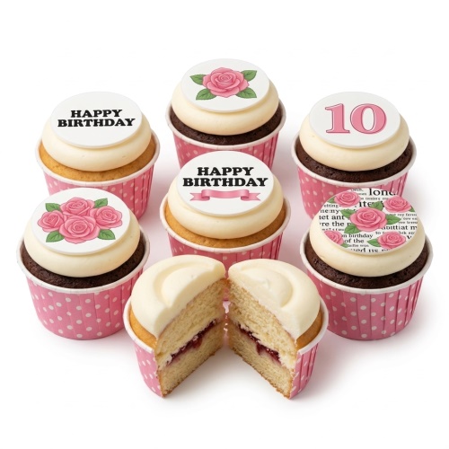 Assortment of birthday cupcakes with white frosting, pink polka dot wrappers, and edible toppers featuring pink roses, 'Happy Birthday' messages, and a custom number.