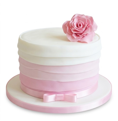 Pink ombre birthday cake with a sugar rose and ribbon bow.