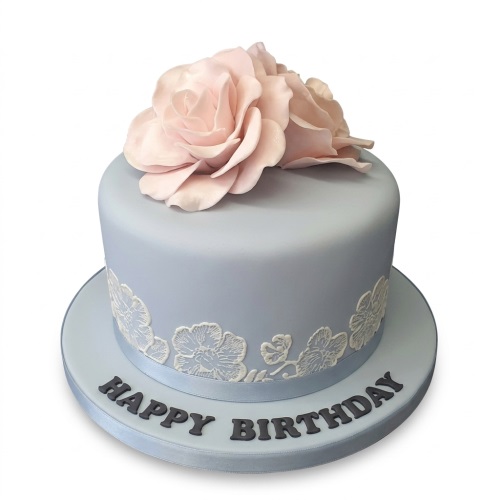 Round light blue birthday cake with pink sugar roses and white lace detail