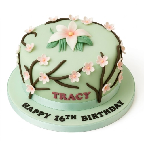 Round mint green birthday cake with pink and white cherry blossom sugar flowers and brown branches, with a personalised message area.
