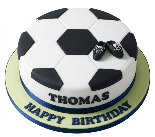 Round football birthday cake with black and white panels and edible football boots.