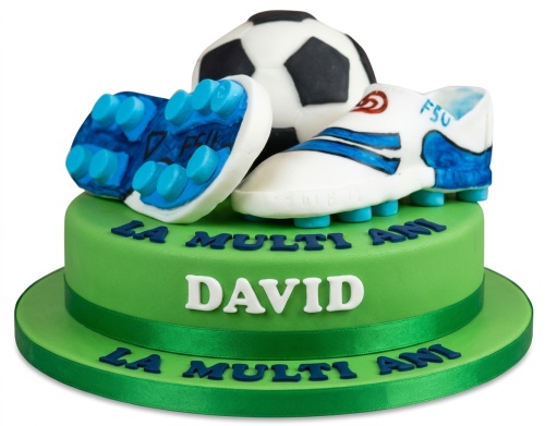 Green football themed birthday cake with edible football boots and a black and white ball.