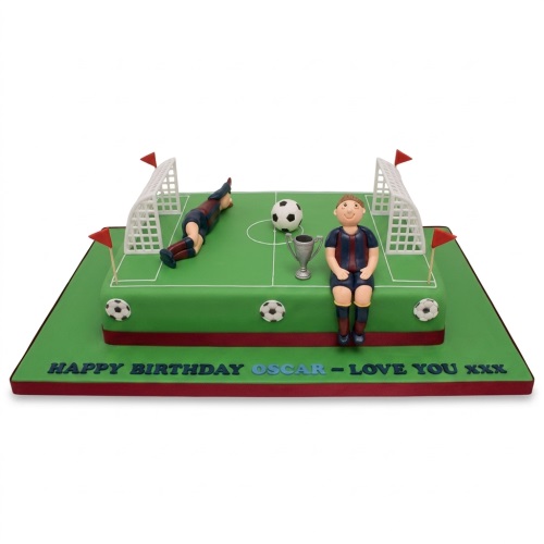 Rectangular football pitch birthday cake with edible players, goals, trophy, and custom message.