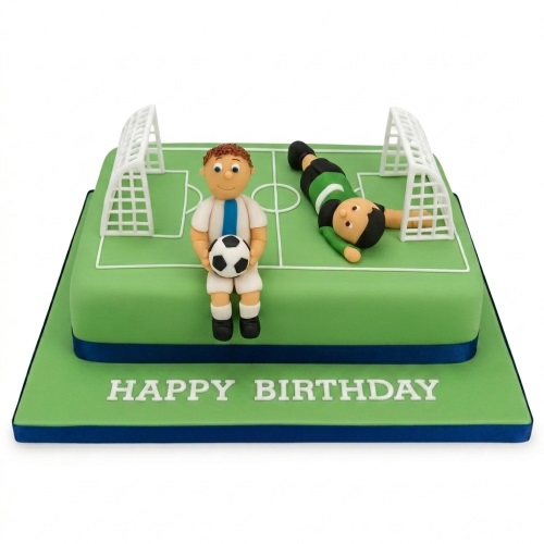Green football pitch cake with white goalposts and two football player figurines, on a blue-edged board with 'Happy Birthday' message.