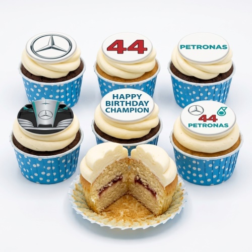 Six cupcakes with white frosting and various Mercedes F1 and Petronas themed edible toppers, including the number 44 and 'Happy Birthday Champion' message, in blue polka dot cases.