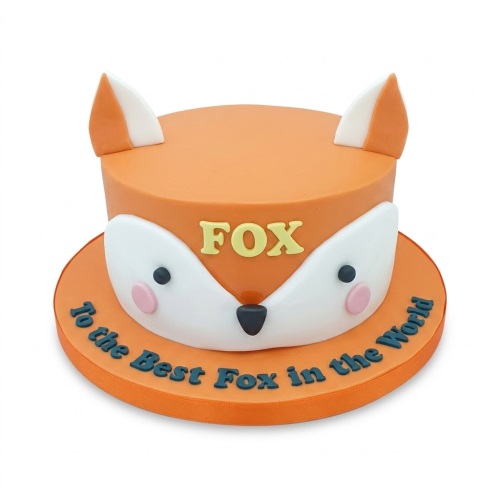 Orange fox-themed round birthday cake with white face and ears, custom message on board.