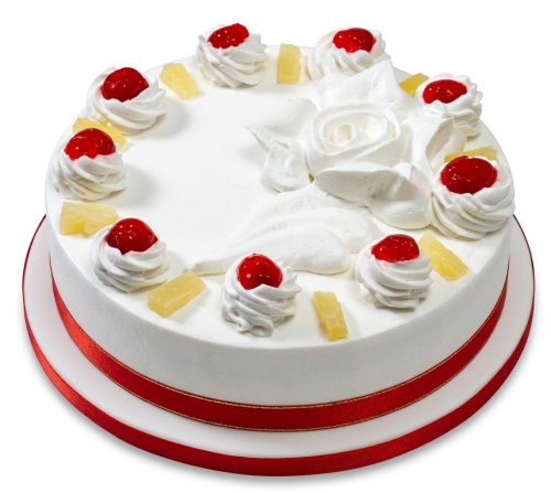 Round white cream cake with piped roses, red cherries, pineapple pieces, and a red ribbon.