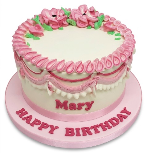 Round white cake with pink piped flowers and elegant detailing for a personalised birthday.