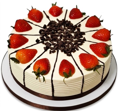 Round fresh cream cake topped with fresh strawberries and chocolate shavings.