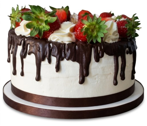 Round white cake with dark chocolate drip, fresh red strawberries, and white cream swirls on top.