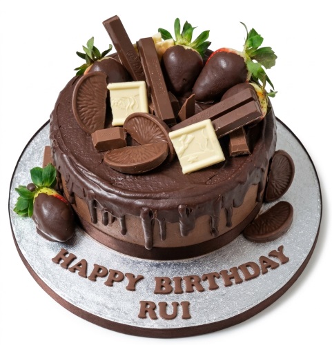 Round chocolate drip birthday cake with chocolate-dipped strawberries, Kit Kats, and chocolate orange segments.