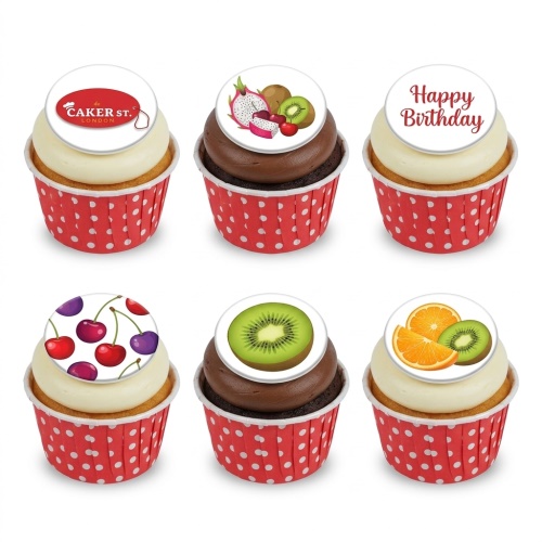 Assortment of fruit-themed cupcakes with edible toppers, including kiwi, cherries, dragon fruit, and orange, in red polka dot wrappers.