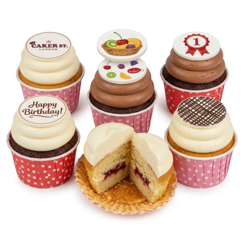 Assorted birthday cupcakes with "Happy Birthday!" message, custom age '1' topper, fruit designs, and chocolate lattice.