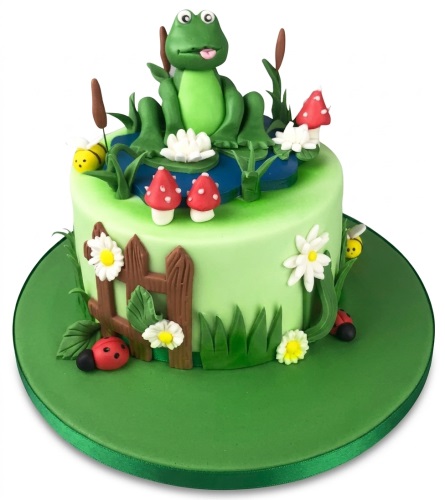 Green round birthday cake with 3D frog, pond, mushrooms, bees, ladybugs, and flowers.