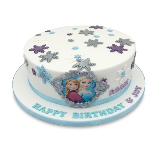 Round white Frozen birthday cake with Elsa and Anna characters and blue and purple snowflakes.