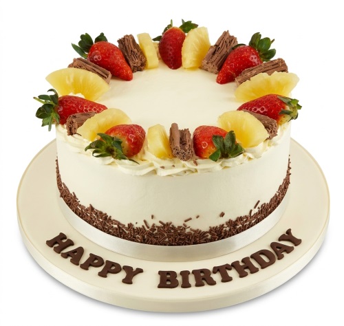 Round fresh cream birthday cake with strawberries, pineapple, and chocolate flakes.