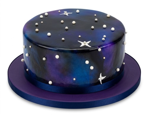 Round galaxy themed cake with blue and purple colours, edible white and silver pearls, and white star decorations.