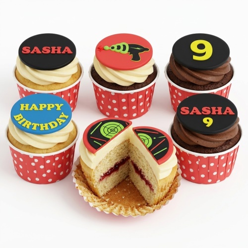 A set of six cupcakes with red polka dot wrappers, decorated with laser gun and target toppers, and 'Happy Birthday' and a custom name/age.