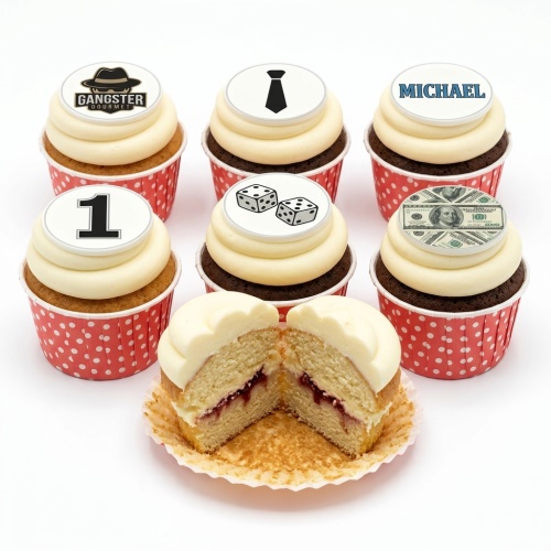 A selection of gangster themed cupcakes with white frosting and red polka dot cases, featuring toppers with a fedora, tie, dice, money, and a custom age number.