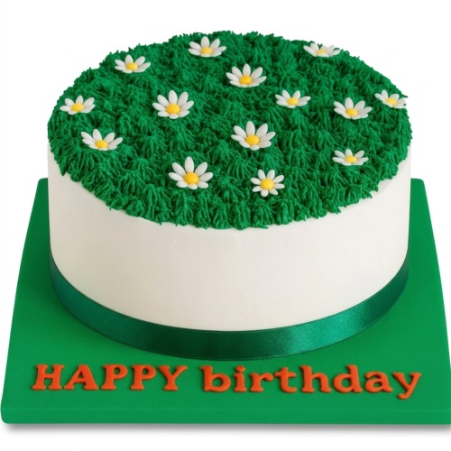 Round white cake with green piped grass top, decorated with white daisies and a green ribbon.