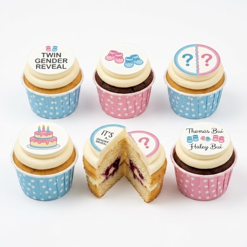 Gender reveal cupcakes with pink and blue baby booties and question mark toppers.