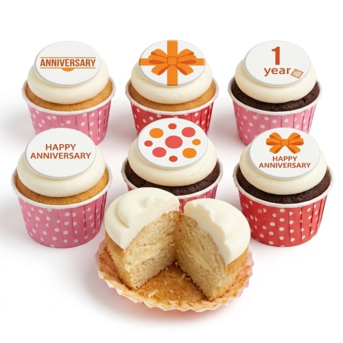 White frosted anniversary cupcakes with orange bow and "Anniversary" toppers in polka dot cases.