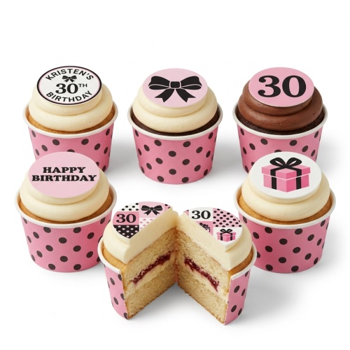 Pink and black polka dot cupcakes with bow, gift box, and custom age toppers.