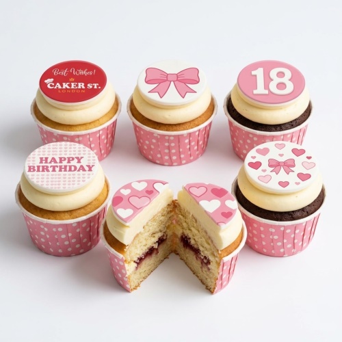 Pink and white cupcakes with bow and heart toppers for a birthday celebration, including a custom age example.