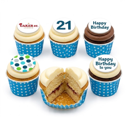Six cupcakes in blue polka dot wrappers with white and brown frosting, some with '21', 'Happy Birthday' or polka dot toppers.