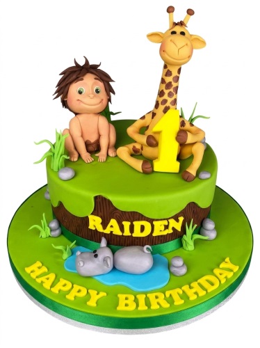 Two-tier green and brown jungle themed birthday cake with a dinosaur character, human character, giraffe, and hippos.
