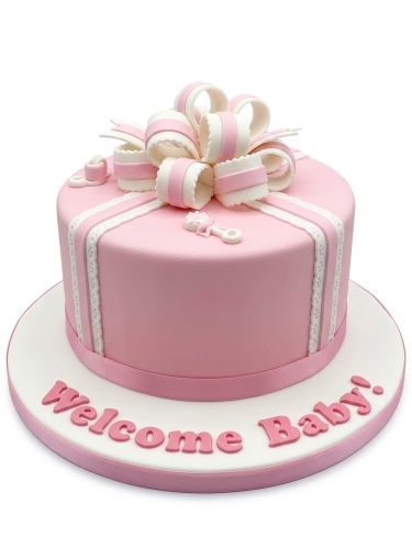 Pink baby shower cake with white bow, ribbons, baby rattle, and 'Welcome Baby!' message.