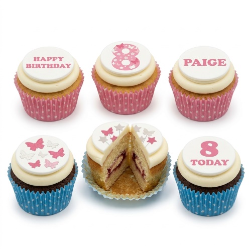 Cupcakes with white frosting and edible toppers featuring pink butterflies, stars, and examples of custom age and personalised messages.