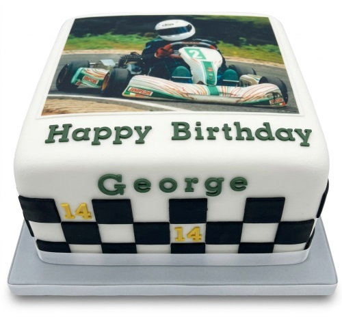 White rectangular birthday cake with a go-kart racer image and checkered flag design.