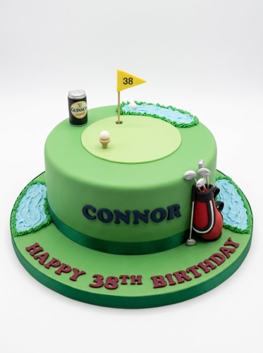 Green golf course birthday cake with custom age flag, golf bag, and miniature drink can.