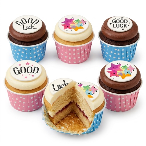 Six cupcakes with 'Good Luck' messages and colourful star toppers in pink and blue polka dot wrappers.