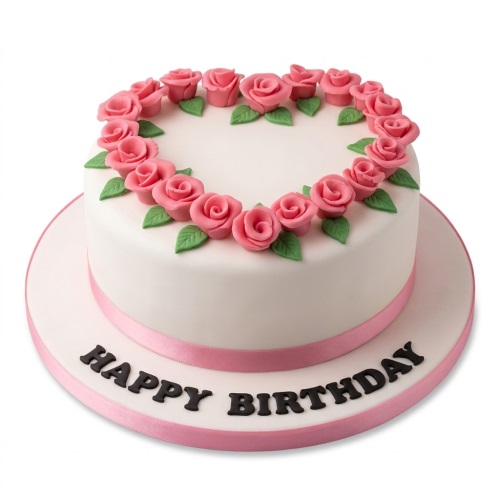 White round birthday cake with pink sugar roses in a heart shape and a pink ribbon.