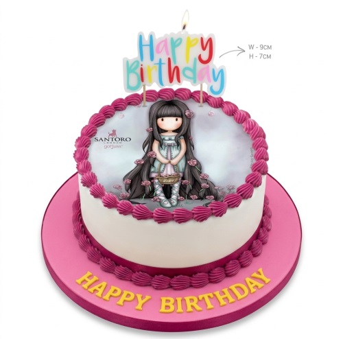 Round white birthday cake with Santoro London Gorjuss doll edible image, pink piping, and Happy Birthday candle topper.