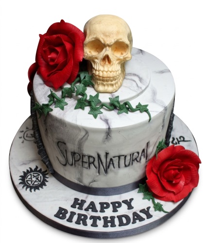 Supernatural themed birthday cake with a skull, red roses, green ivy, and marble effect icing.