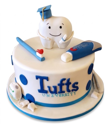 White round cake with tooth character in graduation cap, toothbrush, toothpaste, and university text.