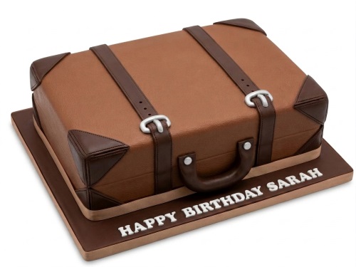 Brown suitcase shaped birthday cake with straps, buckles, and a custom message board.